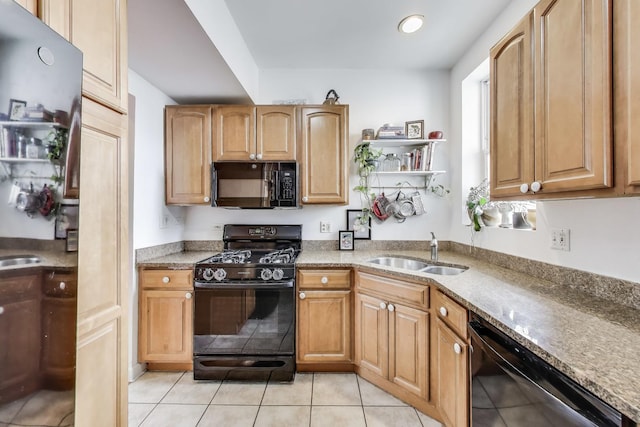 kitchen with a sink, light stone countertops, black appliances, and light tile patterned flooring