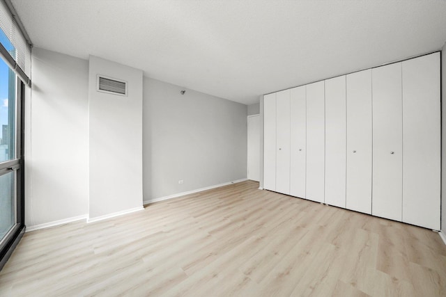 unfurnished bedroom with baseboards, visible vents, and light wood finished floors