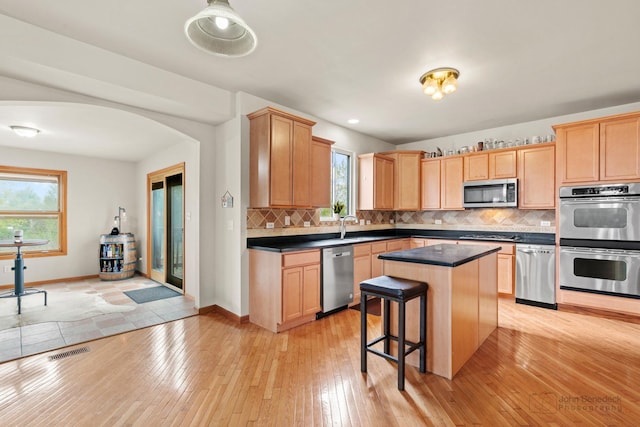 486 Devonaire Pkwy, Dekalb, IL 60115 - kitchen featuring appliances with stainless steel finishes, plenty of natural light, dark countertops, and decorative backsplash
