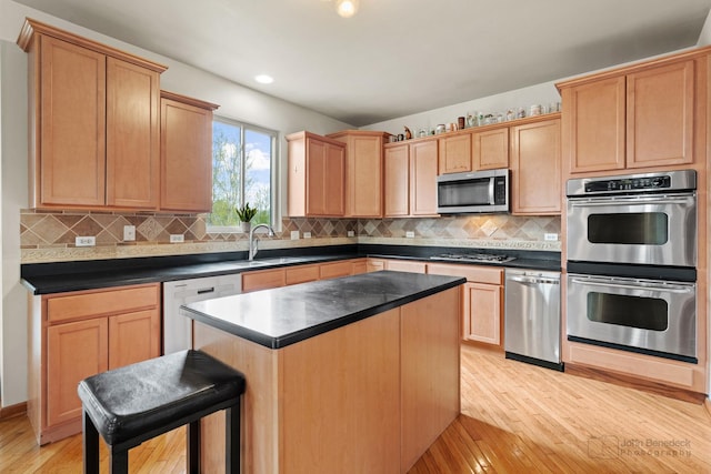 486 Devonaire Pkwy, Dekalb, IL 60115 - kitchen featuring appliances with stainless steel finishes, a sink, light wood finished floors, backsplash, and dark countertops