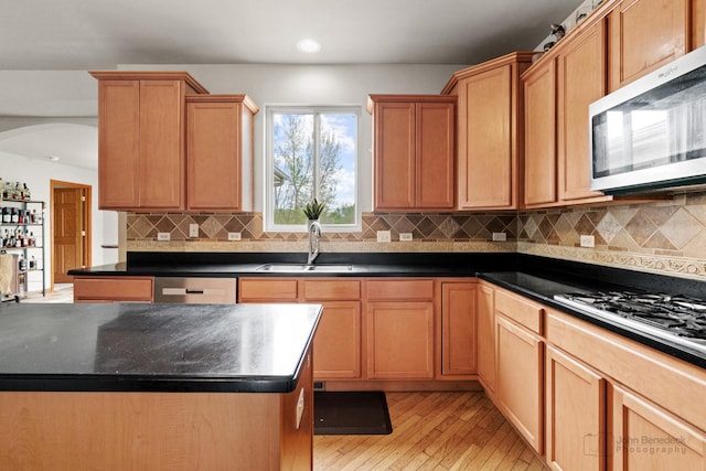 486 Devonaire Pkwy, Dekalb, IL 60115 - kitchen featuring stainless steel microwave, a sink, dishwashing machine, light wood-style floors, and dark countertops