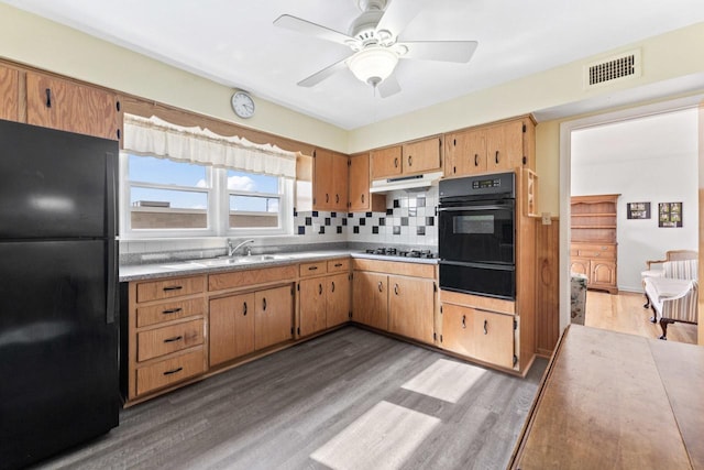 5927 W Addison St Unit 2D, Chicago, IL 60634 - kitchen with black appliances, a warming drawer, a sink, wood finished floors, and under cabinet range hood
