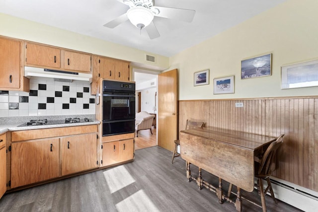 5927 W Addison St Unit 2D, Chicago, IL 60634 - kitchen featuring black appliances, under cabinet range hood, a warming drawer, wood finished floors, and light countertops