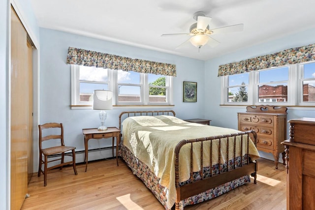 5927 W Addison St Unit 2D, Chicago, IL 60634 - bedroom featuring a baseboard radiator, light wood-style flooring, a closet, and a ceiling fan