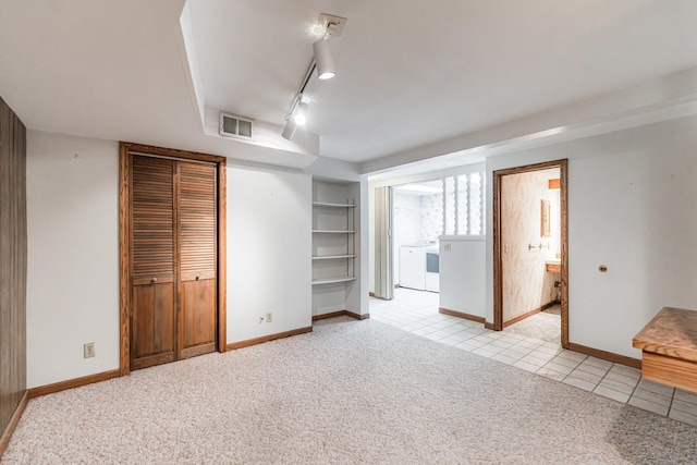 609 Moss Pl, Dixon, IL 61021 - unfurnished bedroom with washer and dryer, light colored carpet, rail lighting, light tile patterned floors, and baseboards