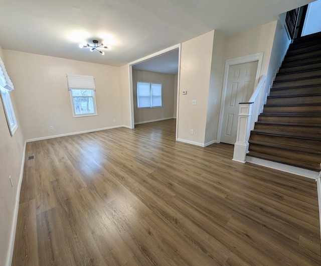 257 Orchard Ave, Kankakee, IL 60901 - unfurnished living room featuring stairs, wood finished floors, and baseboards