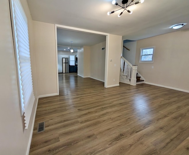 257 Orchard Ave, Kankakee, IL 60901 - unfurnished living room featuring a chandelier, stairway, baseboards, and wood finished floors