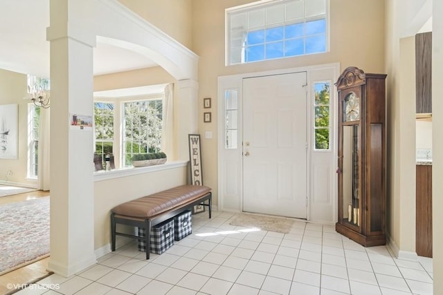 838 Old Checker Rd Unit D-4, Buffalo Grove, IL 60089 - entryway featuring arched walkways, a chandelier, a high ceiling, light tile patterned floors, and baseboards