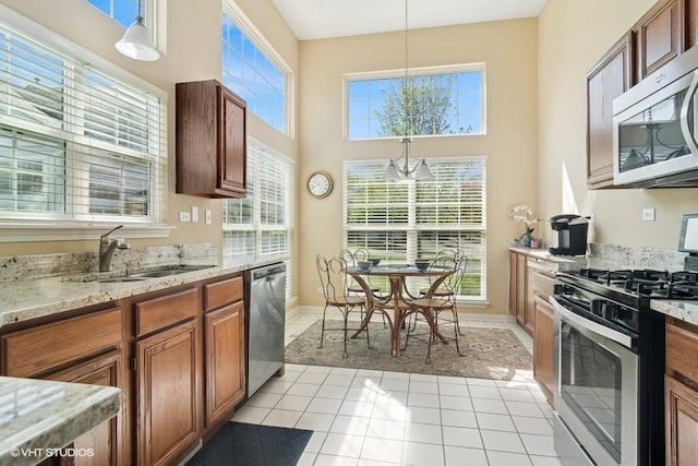 838 Old Checker Rd Unit D-4, Buffalo Grove, IL 60089 - kitchen with stainless steel appliances, a sink, healthy amount of natural light, brown cabinets, and a high ceiling