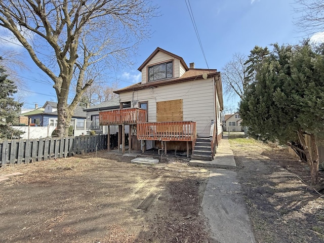back of house featuring fence, a chimney, and a wooden deck