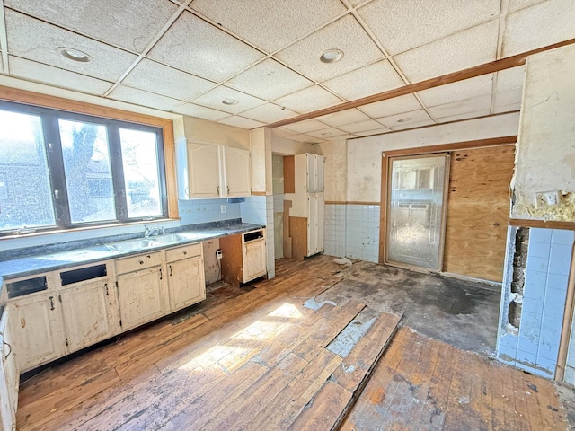 kitchen featuring a drop ceiling, a sink, and light wood-style flooring
