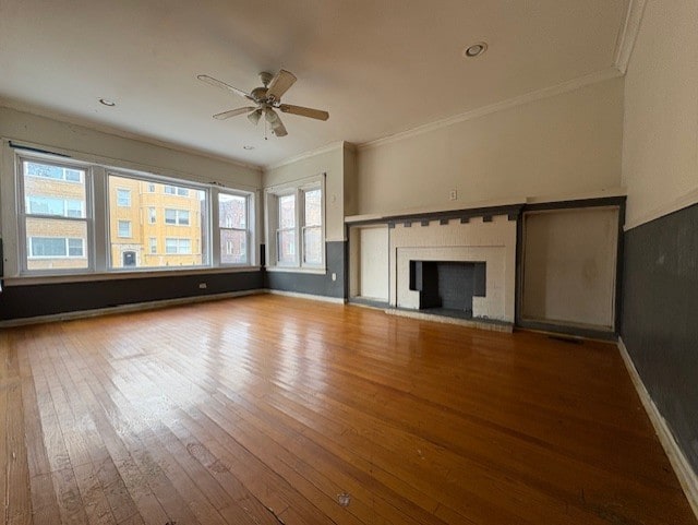 unfurnished living room featuring crown molding, baseboards, a ceiling fan, and wood-type flooring