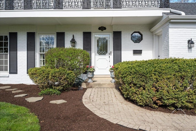 view of exterior entry featuring brick siding