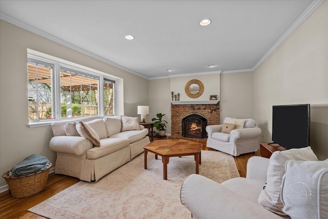 living area with ornamental molding, a fireplace, recessed lighting, and wood finished floors