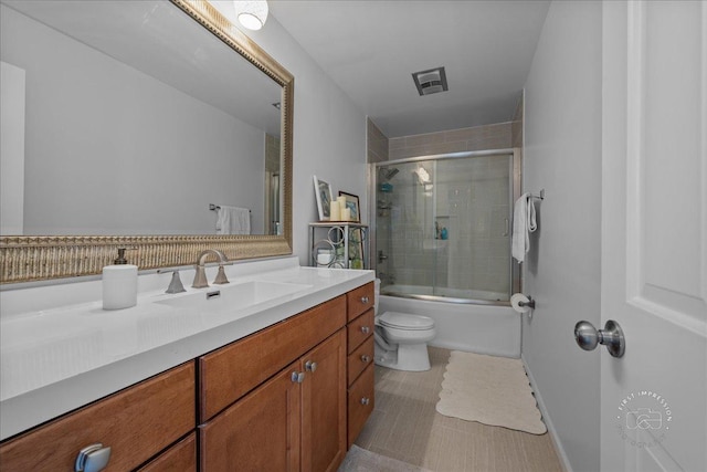 full bathroom featuring visible vents, shower / bath combination with glass door, toilet, and vanity