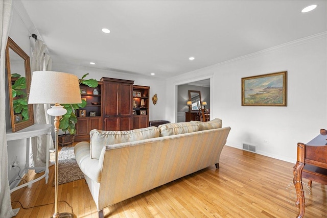 living room featuring crown molding, recessed lighting, visible vents, and light wood finished floors