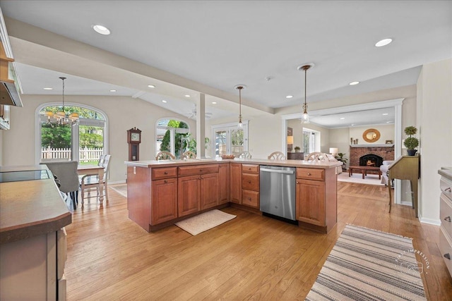 kitchen with a brick fireplace, dishwasher, light countertops, light wood finished floors, and open floor plan