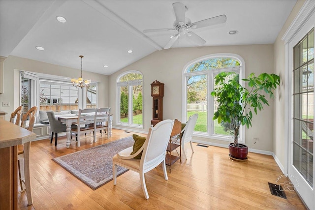 dining room with lofted ceiling with beams, ceiling fan with notable chandelier, light wood finished floors, and visible vents