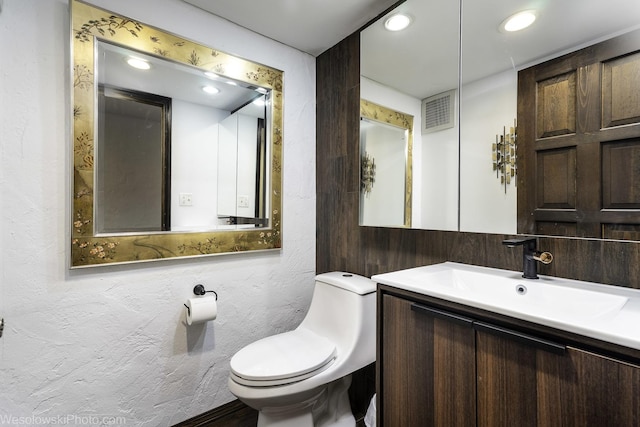 bathroom with vanity, toilet, recessed lighting, and visible vents
