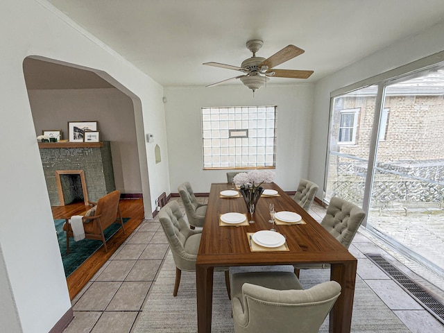 1714 W Beverly Glen Pkwy, Chicago, IL 60643 - dining room with a brick fireplace, baseboards, arched walkways, a ceiling fan, and light tile patterned floors