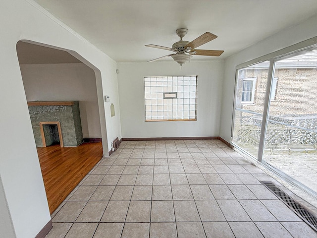 1714 W Beverly Glen Pkwy, Chicago, IL 60643 - unfurnished living room with visible vents, a fireplace, arched walkways, a ceiling fan, and light tile patterned floors