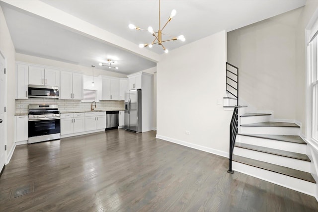 kitchen with white cabinets, an inviting chandelier, stainless steel appliances, backsplash, and visible vents
