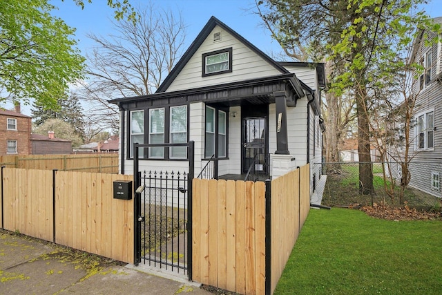 shotgun-style home with a gate and a fenced front yard