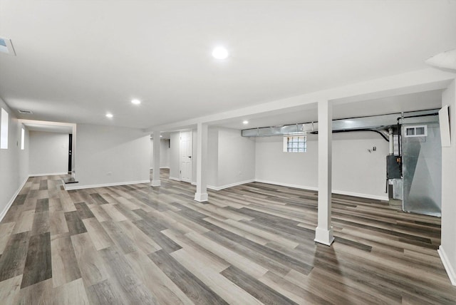 below grade area with baseboards, recessed lighting, wood finished floors, and visible vents