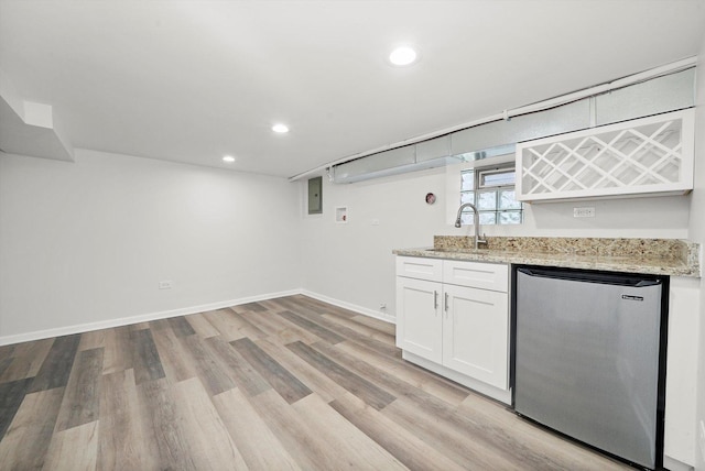 bar featuring stainless steel refrigerator, light wood-style floors, recessed lighting, a sink, and wet bar