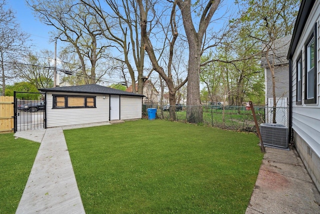 view of yard with a gate, a fenced backyard, an outbuilding, and central AC unit
