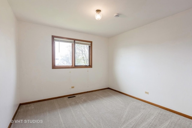 empty room with visible vents, carpet, and baseboards