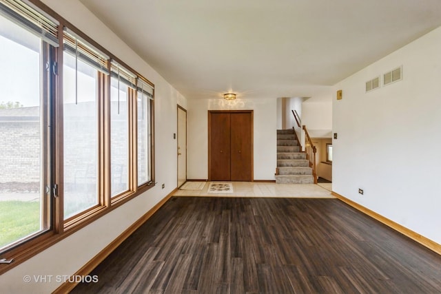 entrance foyer featuring baseboards, stairs, wood finished floors, and visible vents