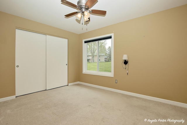 unfurnished bedroom featuring baseboards, a closet, light carpet, and ceiling fan