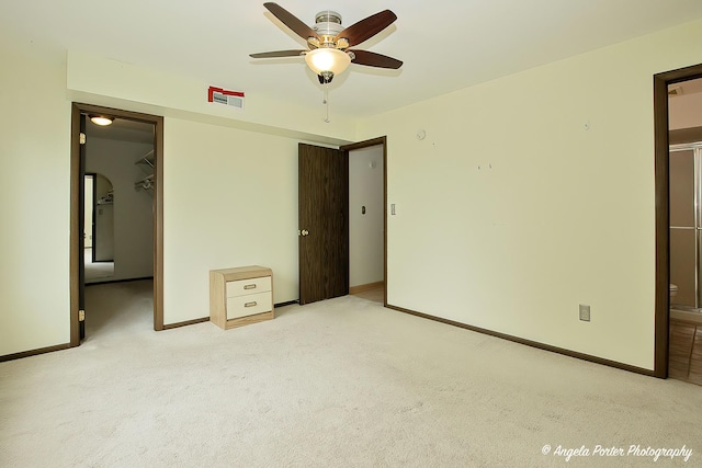 unfurnished bedroom featuring baseboards, carpet, a closet, and a spacious closet