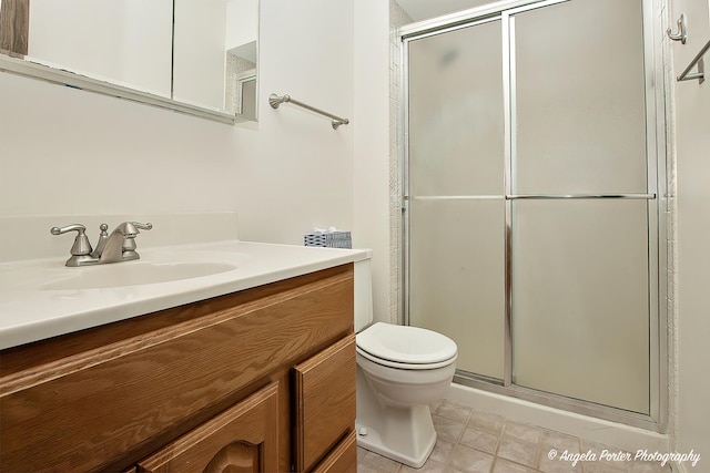 full bath featuring toilet, a shower stall, tile patterned flooring, and vanity