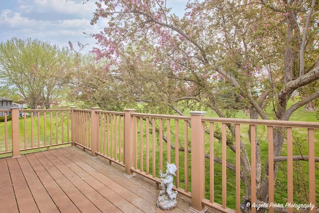 wooden deck featuring a lawn