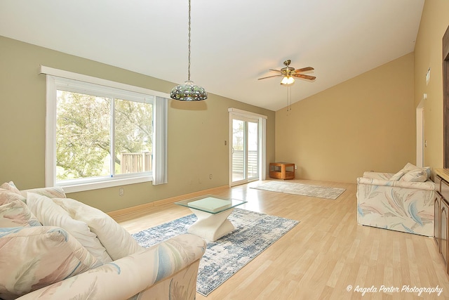 living area featuring a ceiling fan, wood finished floors, and lofted ceiling