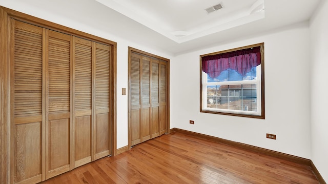 7022 W 64th St, Chicago, IL 60638 - unfurnished bedroom featuring baseboards, visible vents, light wood finished floors, and multiple closets