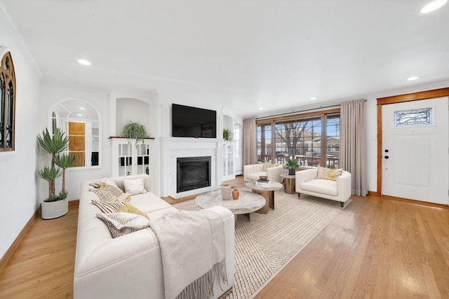 7022 W 64th St, Chicago, IL 60638 - living area with a glass covered fireplace, light wood-style flooring, and baseboards