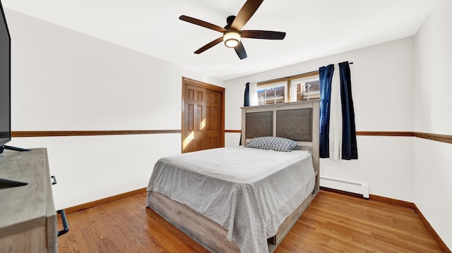 7022 W 64th St, Chicago, IL 60638 - bedroom with wood finished floors, ceiling fan, a baseboard heating unit, and baseboards