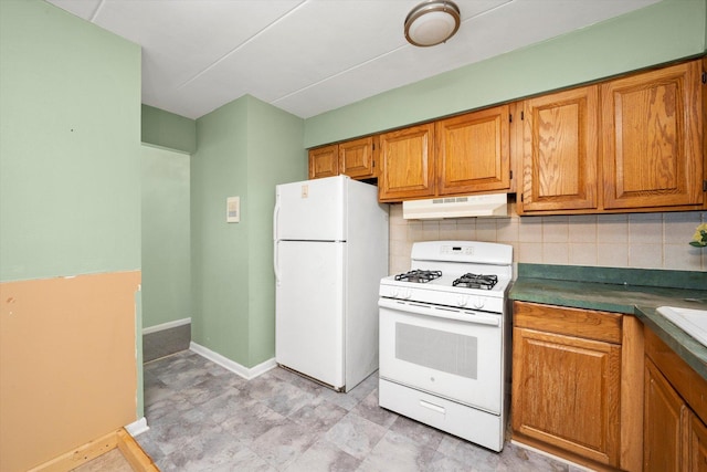 kitchen with white appliances, brown cabinets, under cabinet range hood, and tasteful backsplash