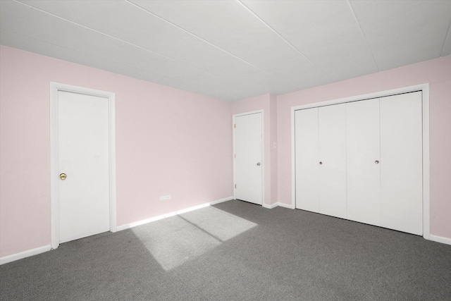 unfurnished bedroom featuring baseboards, carpet, and a closet