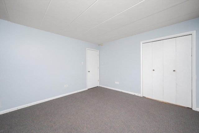 unfurnished bedroom with carpet floors, baseboards, and a closet