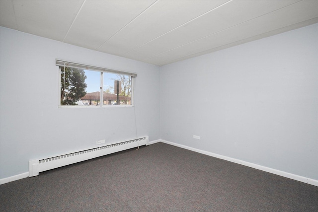 empty room featuring baseboards, baseboard heating, and dark colored carpet