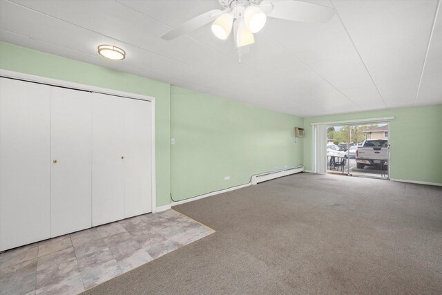 unfurnished living room featuring carpet flooring, ceiling fan, a baseboard heating unit, and baseboards