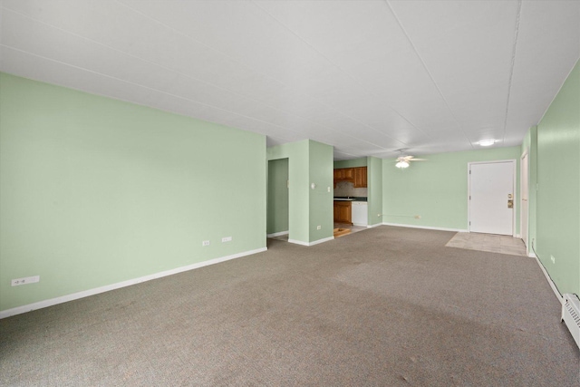 unfurnished living room featuring carpet floors, ceiling fan, and baseboards
