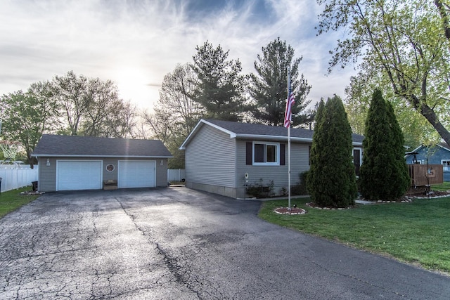 view of home's exterior with an outdoor structure, a garage, fence, and a yard