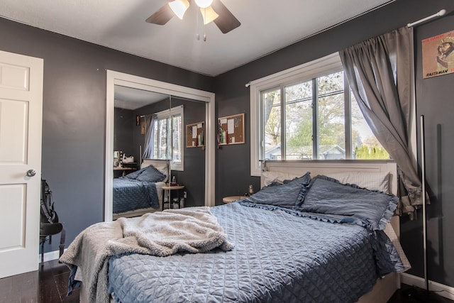 bedroom with baseboards, a ceiling fan, a closet, and wood finished floors