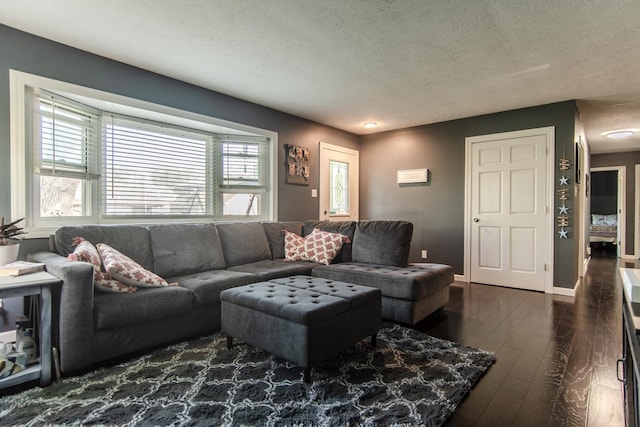 living area with a textured ceiling, dark wood-style floors, and baseboards