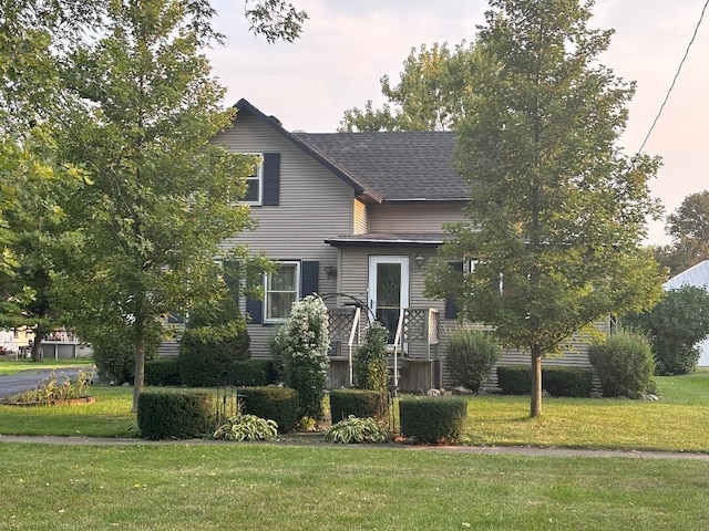 view of front of home featuring a shingled roof and a front yard